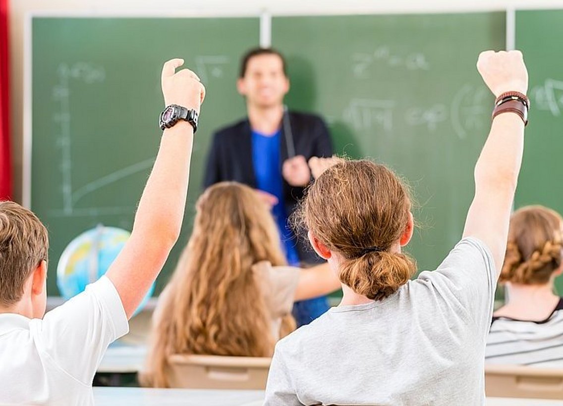 Schulkinder, die aufzeigen